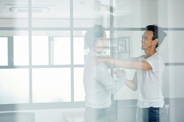 Aufgeregter Mann, der Freund im Büro trifft