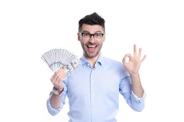Aufgeregter Mann, der Papiergeld hält, zeigt ok Geste im Studio Reicher Mann, der mit Geldscheinen lächelt
