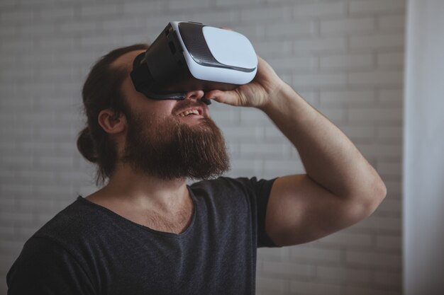 Aufgeregter Mann, der VR-Gläser verwendet