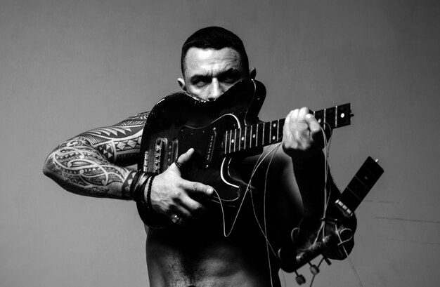 Foto aufgeregter sexy mann mit elektrischer gitarre musik-performance-unterhaltung