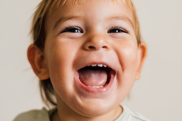 Aufgeregtes Gesicht eines kleinen Babykleinkindes auf weißem Hintergrund