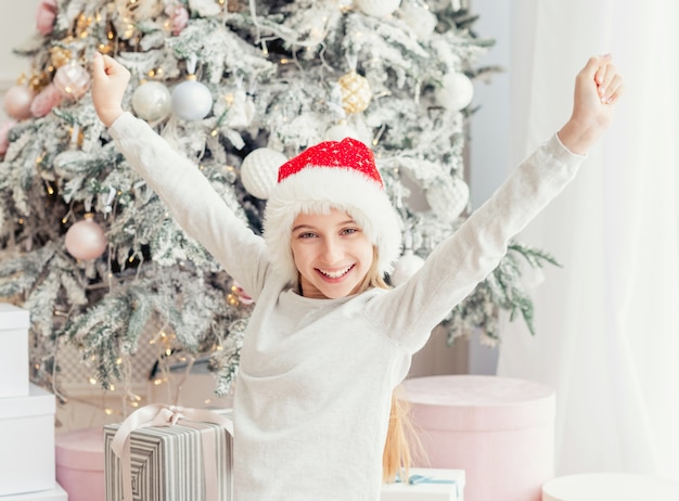 Aufgeregtes junges Mädchen nahe Weihnachtsbaum