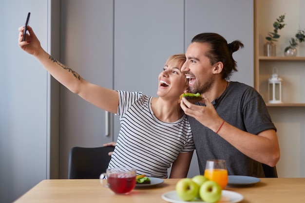 Aufgeregtes Paar, das am Morgen Selfie macht