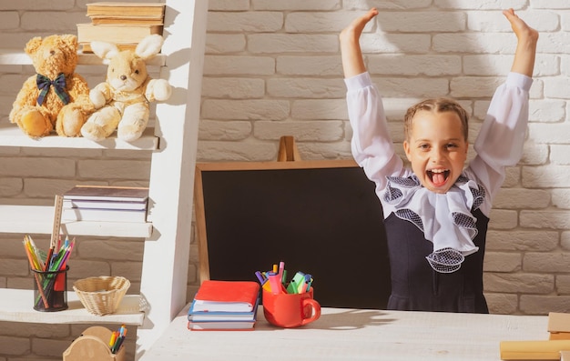 Aufgeregtes Schulmädchen im Klassenzimmer in der Schule erstaunte das Bildungs- und Studienkonzept der Kinder