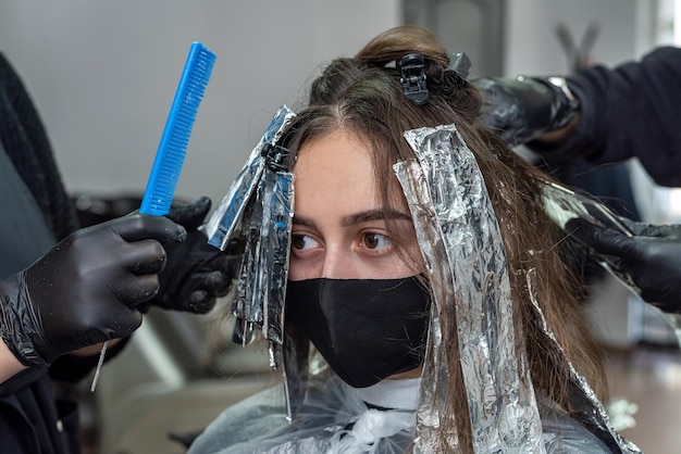 Aufhellen von dunklem, schönem Haar mit Farbe, um im Schönheitssalon eine andere Farbe zu erhalten. Haarfärbekonzept