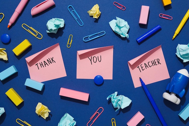 Foto aufkleber mit aufschriften „danke lehrer“ auf blauem hintergrund mit briefpapier
