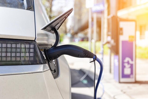 Foto aufladen der batterie eines elektrofahrzeugs mit grüner energie an einer ladestation