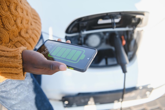 Aufladen des Telefons im Autokonzept, Nahaufnahme des Smartphone-Ladegeräts im Armaturenbrett des Autos