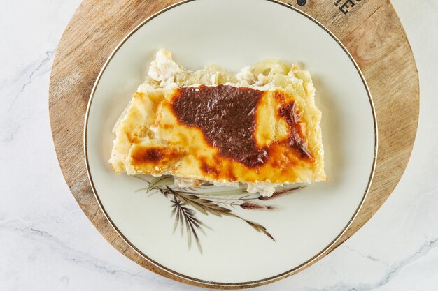 Auflaufkuchen mit Käse und Sauerampfer auf Teller auf hellem Hintergrund.