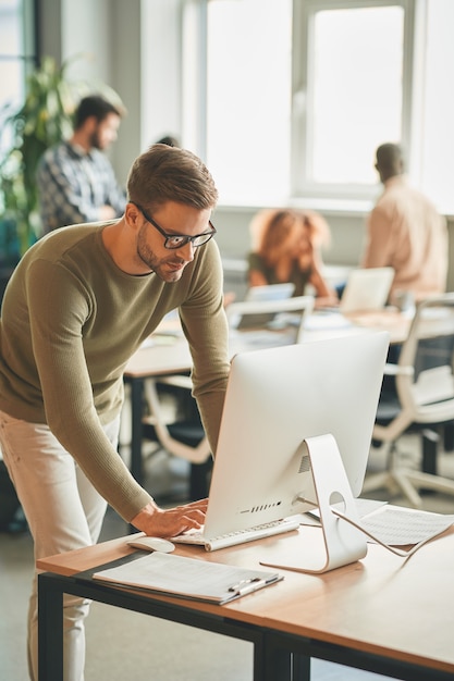 Aufmerksamer Büroangestellter mit Computer am Arbeitsplatz