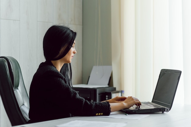 Aufnahme einer attraktiven reifen Geschäftsfrau, die an einem Laptop in ihrer Arbeitsstation arbeitet