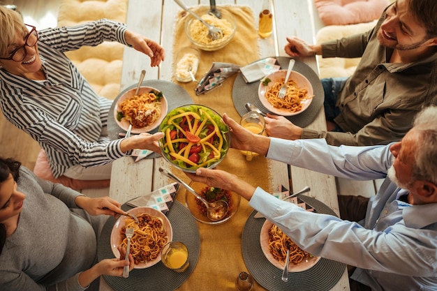 Aufnahme einer Familie, die drinnen zusammen eine Mahlzeit zu sich nimmt Ansicht von oben