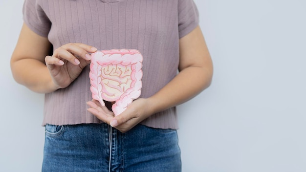 Aufnahme einer Frau, die Papier mit Darm auf weißem Hintergrund mit Kopierraum hält