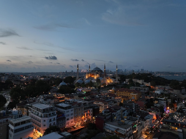 Aufnahme einer Hagia-Sophia-Moschee mit Bosporusbrücke und Stadt-Skyline mit einer Flagge im Hintergrund in Fatih Istanbul, Türkei bei Sonnenuntergang