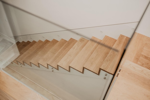 Aufnahme einer Holztreppe mit Glasgeländer in einer modernen Wohnung aus der Vogelperspektive