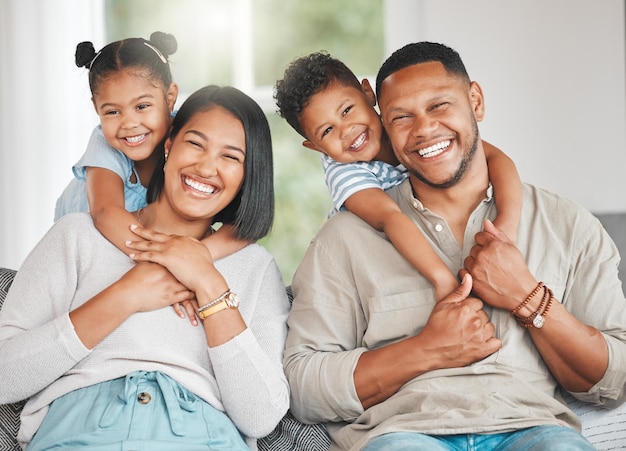 Aufnahme einer jungen Familie, die glücklich auf dem Sofa zu Hause zusammensitzt