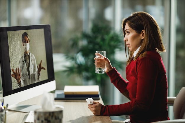 Aufnahme einer jungen Frau, die einen Videoanruf mit ihrem Arzt auf einem Computer führt.