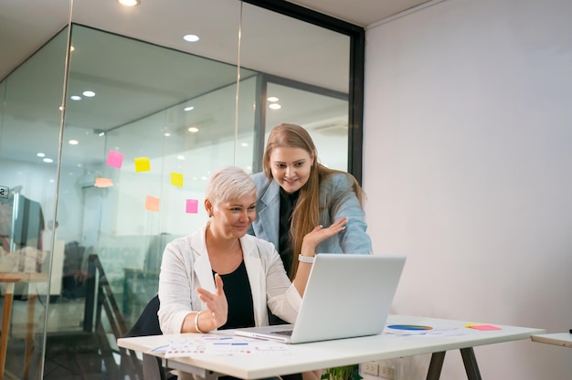 Aufnahme einer reifen Geschäftsfrau, die im Büro sitzt und ihr Team trainiert