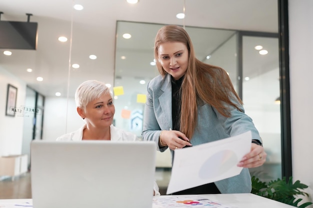 Aufnahme einer reifen Geschäftsfrau, die im Büro sitzt und ihr Team trainiert