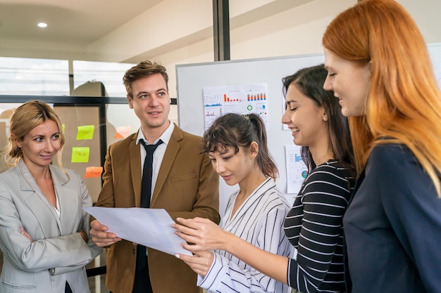 Aufnahme einer reifen Geschäftsfrau, die im Büro sitzt und ihr Team trainiert