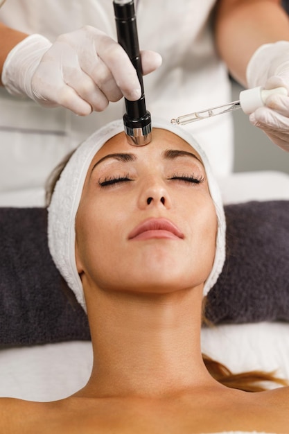 Aufnahme einer schönen jungen Frau bei einer Gesichtsmesotherapie ohne Nadelbehandlung im Schönheitssalon.
