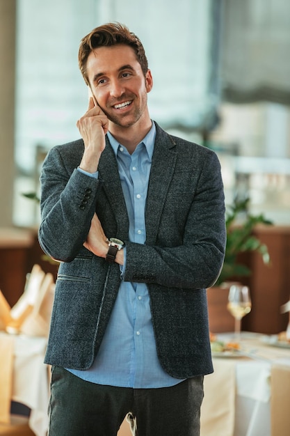 Aufnahme eines glücklichen Mannes, der in einem Restaurant telefoniert