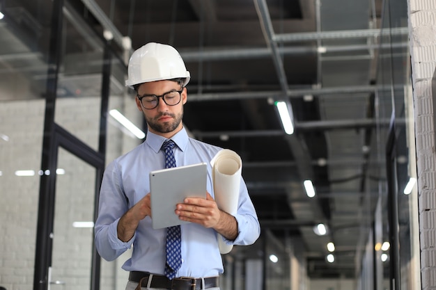 Aufnahme eines Ingenieurs mit einem digitalen Tablet auf einer Baustelle.