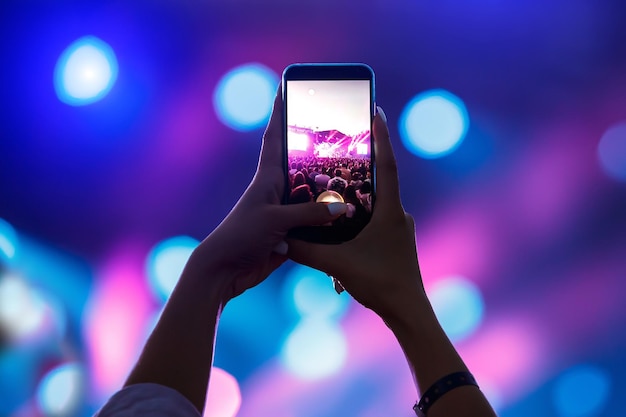 Aufnahme eines Konzerts mit Handy-Silhouette von Händen mit Smartphone