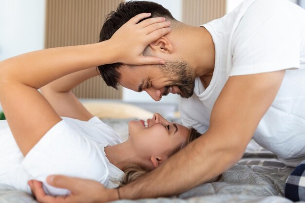 Aufnahme eines liebevollen jungen Paares, das einen romantischen Moment im Schlafzimmer zu Hause teilt