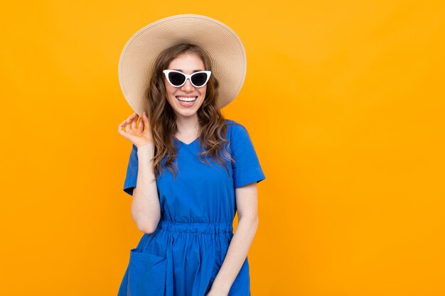 Aufnahme eines Mädchens in einem blauen Kleid an einer gelben Wand