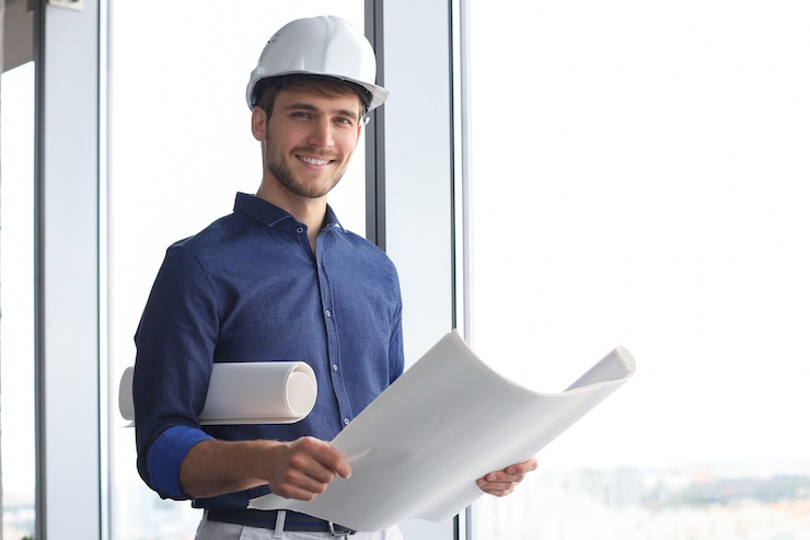 Foto aufnahme eines männlichen architekten, der einen helm trägt und ein neues gebäude inspiziert.