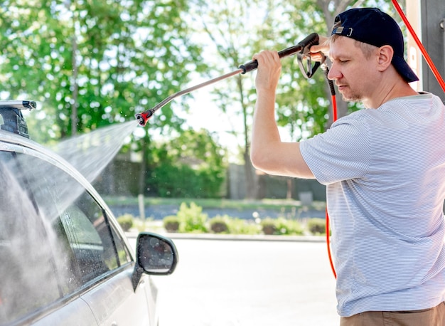 Aufnahme eines Mannes, der sein Auto wäscht