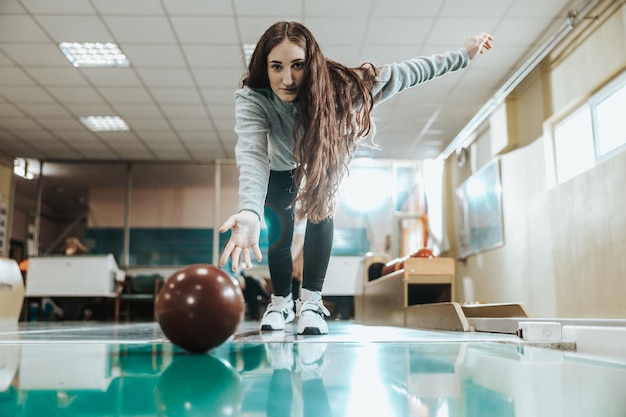 Aufnahme eines süßen Mädchens, das die Bowlingkugel wirft.