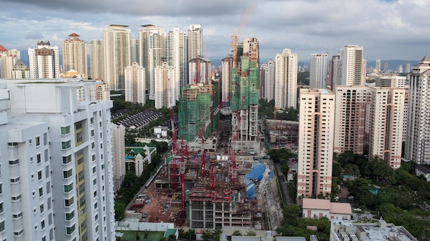 Aufnahme von Bauarbeiten im Wohngebiet von Kuala Lumpur mit Wohnhochhäusern. Wolken segeln über die Stadt und die Nacht kommt