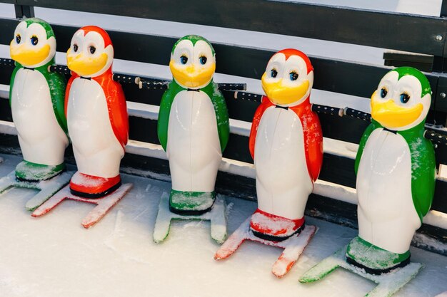 Foto aufnahme von spezieller ausrüstung, die zum schlittschuhfahren benötigt wird, die den menschen hilft, das gleichgewicht auf der eisbahn zu halten helfer für anfänger von schlittschuhlern bunte figuren in form von pinguinen