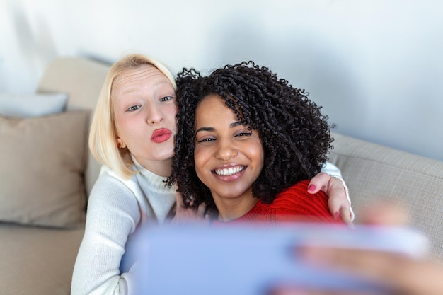 Aufnahme von zwei Freundinnen, die ein Selfie in der Wohnung machen Meine Mitbewohner Aufnahme von zwei jungen Frauen, die ein Selfie machen, während sie zu Hause sitzen WG-Mitbewohner machen ein Selfie