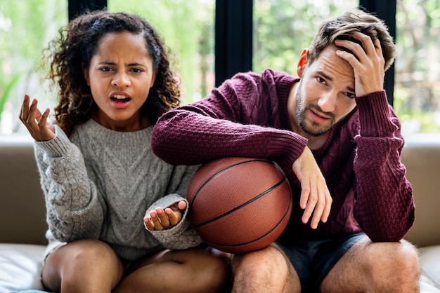 Aufpassendes Basketballspiel der jungen Paare zu Hause