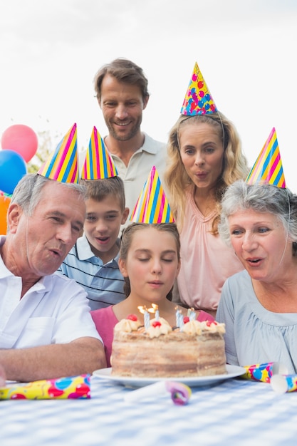 Aufpassendes Mädchen der Cheeful-Familie, das heraus Kerzen an der Geburtstagsfeier ausbrennt