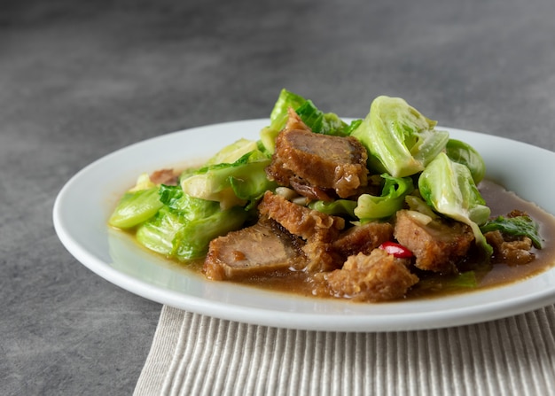 Aufruhr Fried Baby Cabbage mit knusperigem Schweinefleisch auf Platte, asiatisches Lebensmittel