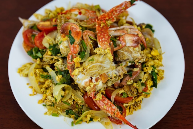 Foto aufruhr fried crab mit curry powder, nahaufnahme, thailändisches lebensmittel auf einem hölzernen hintergrund