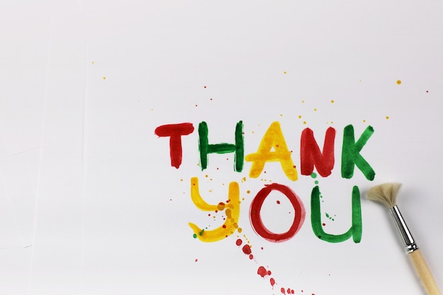 Aufschrift auf einem weißen Blatt Papier mit Wasserfarben "Danke"