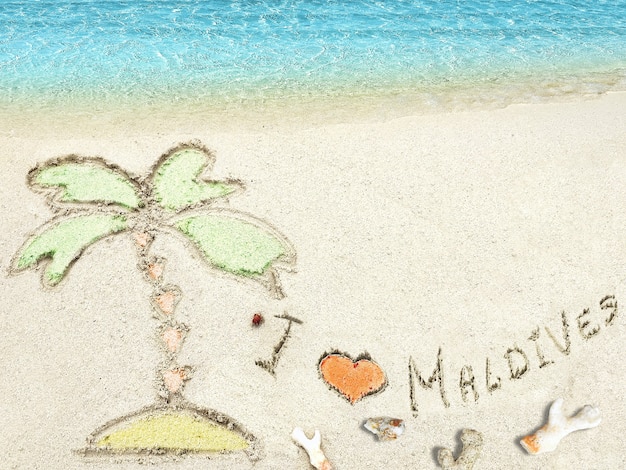 Aufschrift "I LOVE MALDIVES" im Sand auf einer tropischen Insel, Malediven.