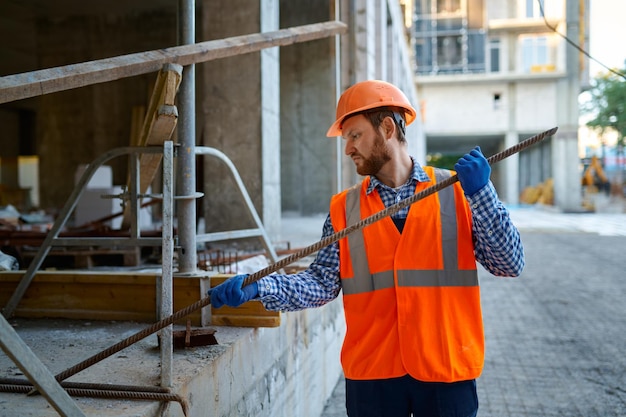 Auftragnehmer, der auf der Baustelle mit Metallbeschlägen arbeitet. Werkzeuge für Bewehrungsbauarbeiten