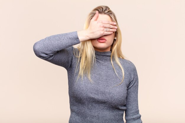 Augen mit einer Hand bedecken, sich ängstlich oder ängstlich fühlen, sich wundern oder blind auf eine Überraschung warten