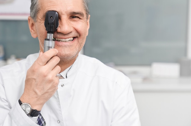 Augenarzt, der Kamera durch ophthalmologisches Werkzeug betrachtet