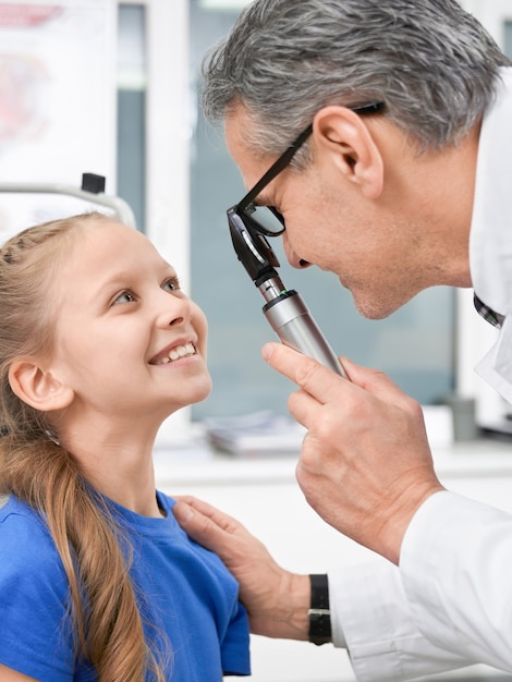 Augenarztprüfung mit Spezialwerkzeugaugen des Mädchens in der Klinik