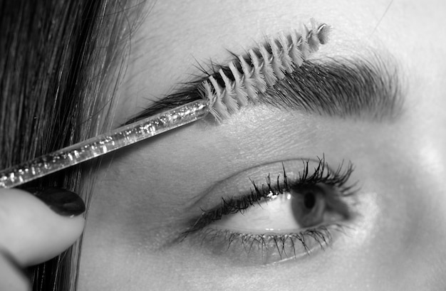 Augenbrauen-Make-up Makro-Nahaufnahme der Augenbrauen. Schönheitsmodell formt die Augenbrauen mit einem Augenbrauenstift in Nahaufnahme. Schöne Frau formt die Augenbrauen. Schönes weibliches Auge mit perfekt geformten Augenbrauen