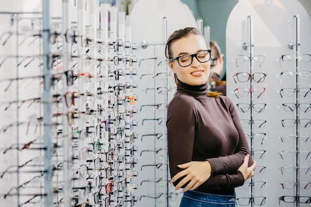 Augenheilkunde Junge Frau wählt eine Brille im Optikergeschäft Augenkorrektur