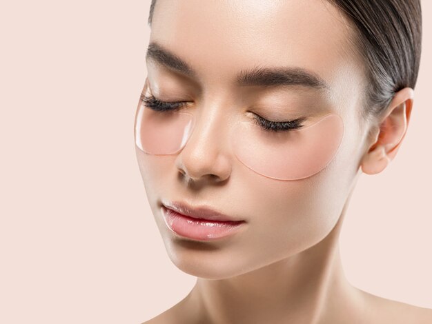 Augenmaske asiatische Frauengesichtskosmetik. Farbiger Hintergrund. Rosa