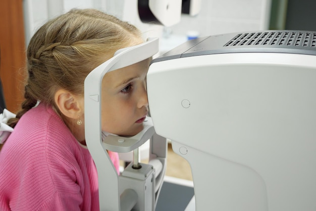 Augenoptiker untersucht den Anblick des kleinen Mädchens.